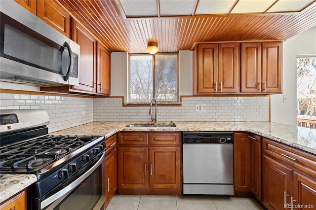kitchen with sink, light tile patterned flooring, tasteful backsplash, and stainless steel appliances