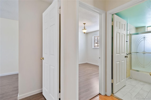 hall featuring a textured ceiling