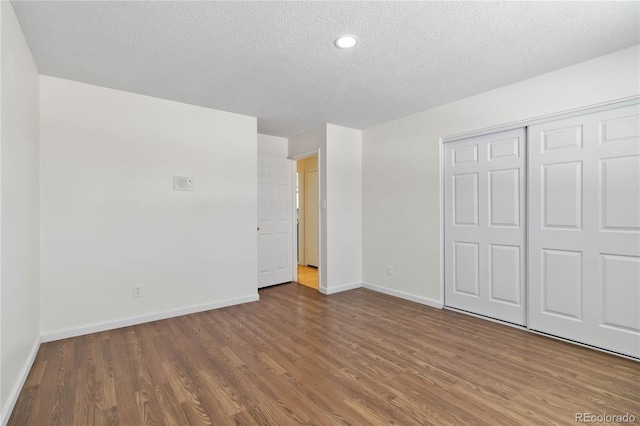 unfurnished bedroom with a closet, hardwood / wood-style flooring, and a textured ceiling