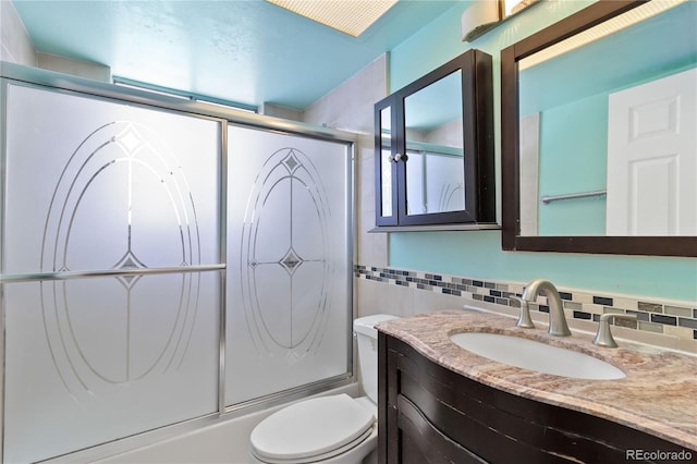 full bathroom with backsplash, enclosed tub / shower combo, vanity, and toilet