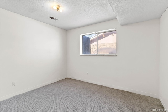 carpeted empty room with a textured ceiling