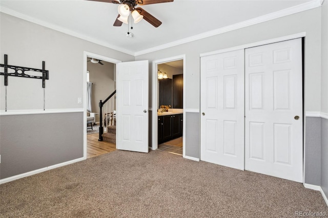 unfurnished bedroom with sink, light colored carpet, crown molding, ensuite bath, and a closet