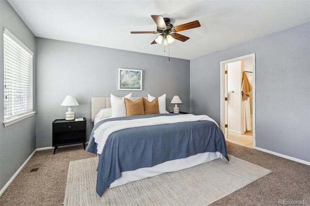 bedroom featuring ensuite bathroom, light carpet, and ceiling fan