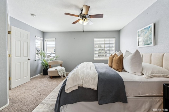 carpeted bedroom with multiple windows and ceiling fan