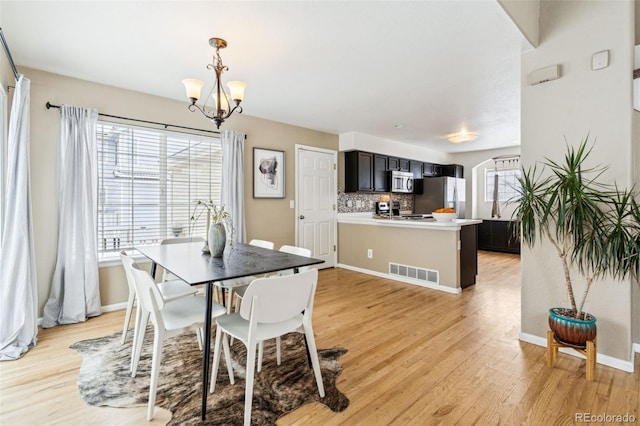 dining room featuring an inviting chandelier and light hardwood / wood-style floors