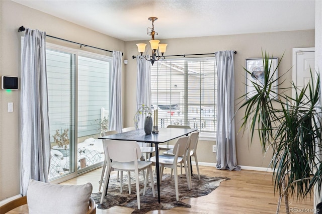 dining area featuring a notable chandelier and light hardwood / wood-style floors