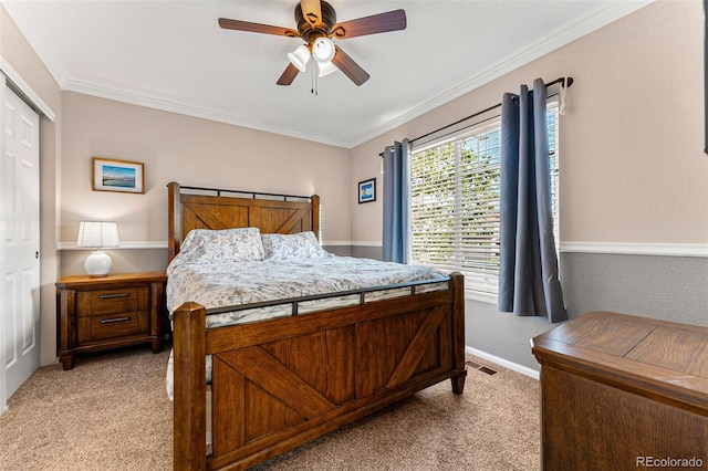 carpeted bedroom featuring crown molding, a closet, and ceiling fan