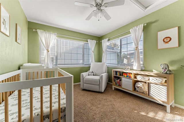 bedroom with a crib, carpet, and ceiling fan