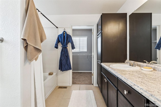 bathroom with vanity, tiled shower / bath combo, and tile patterned floors