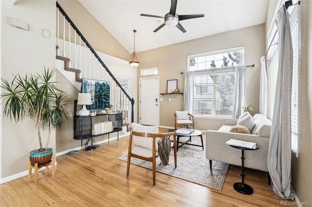 living area featuring wood-type flooring, high vaulted ceiling, and ceiling fan