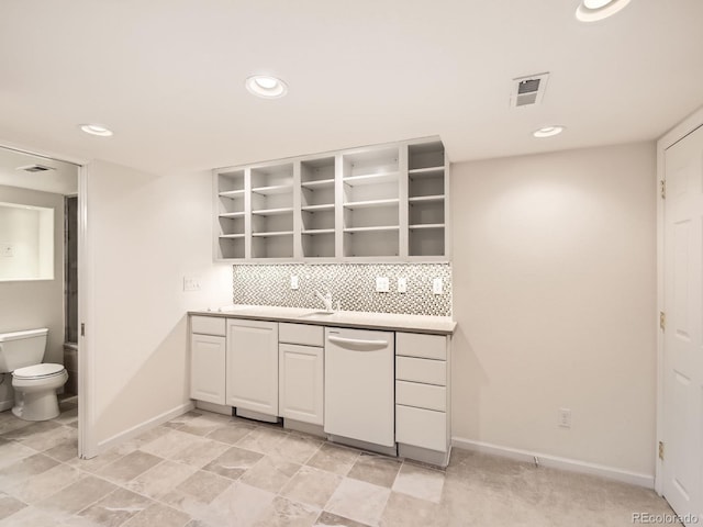 kitchen featuring white cabinets, dishwasher, tasteful backsplash, and sink