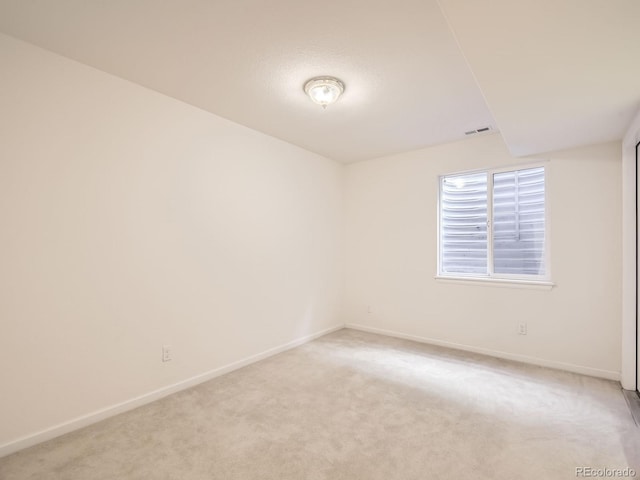 unfurnished room featuring light carpet