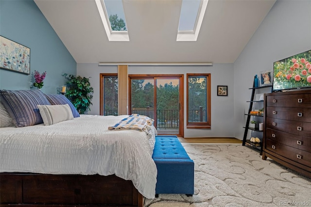 bedroom with access to exterior, vaulted ceiling with skylight, and wood finished floors