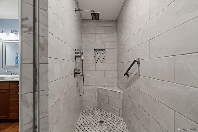 full bathroom featuring vanity, wood finished floors, and a tile shower