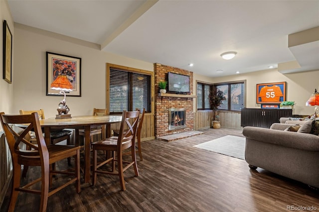 dining area featuring recessed lighting, a brick fireplace, dark wood-type flooring, and baseboards