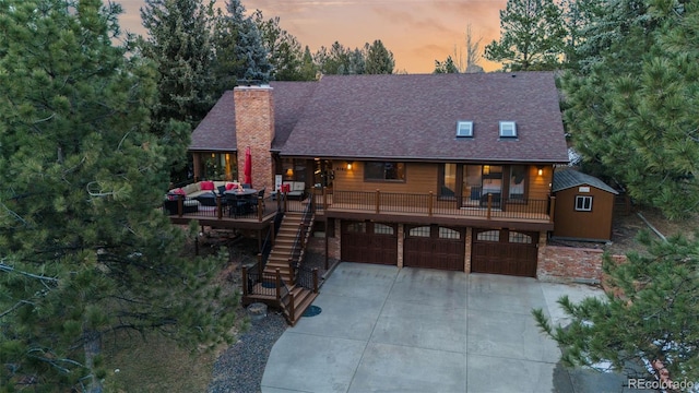 rustic home with stairs, concrete driveway, an attached garage, and a shingled roof