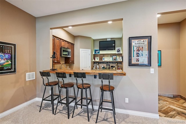 12121 Bryant St, Westminster, CO 80234 - indoor wet bar featuring stainless steel microwave and baseboards