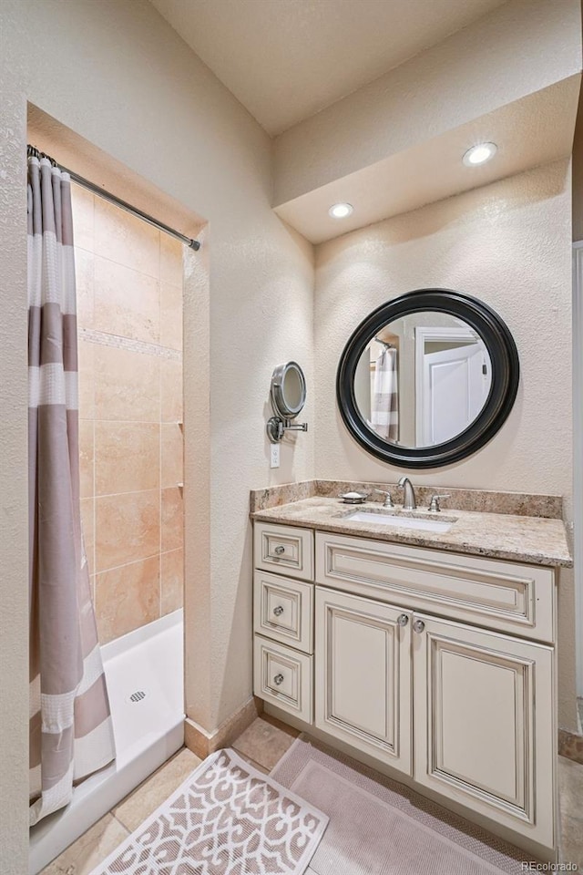 12121 Bryant St, Westminster, CO 80234 - bathroom with vanity, a tile shower, tile patterned floors, and recessed lighting