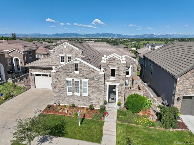 12121 Bryant St, Westminster, CO 80234 - view of front of property with stone siding, concrete driveway, and a mountain view