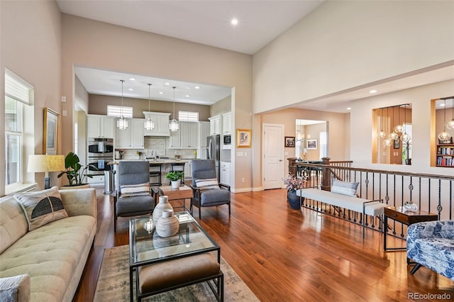 12121 Bryant St, Westminster, CO 80234 - living area featuring wood finished floors, a towering ceiling, a chandelier, and recessed lighting