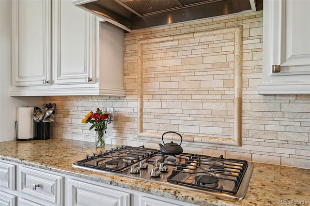 12121 Bryant St, Westminster, CO 80234 - kitchen with stainless steel gas cooktop, custom exhaust hood, white cabinets, and backsplash
