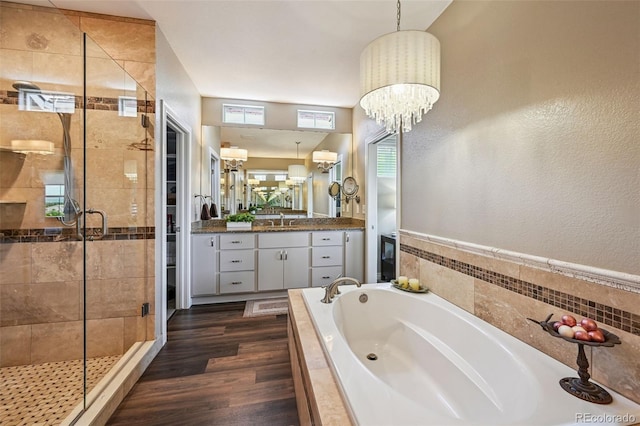 12121 Bryant St, Westminster, CO 80234 - bathroom with a garden tub, a shower stall, vanity, wood finished floors, and a chandelier