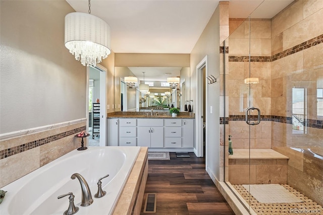 12121 Bryant St, Westminster, CO 80234 - full bathroom with a bath, vanity, a shower stall, wood finished floors, and a chandelier
