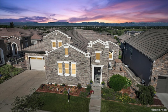 12121 Bryant St, Westminster, CO 80234 - view of front of home with stone siding, concrete driveway, a mountain view, and a residential view