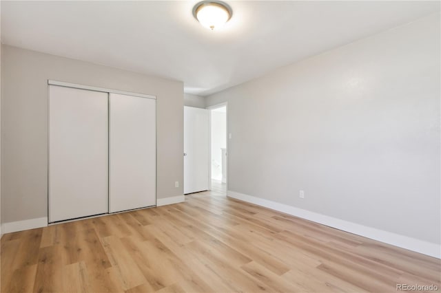 unfurnished bedroom with light hardwood / wood-style floors and a closet