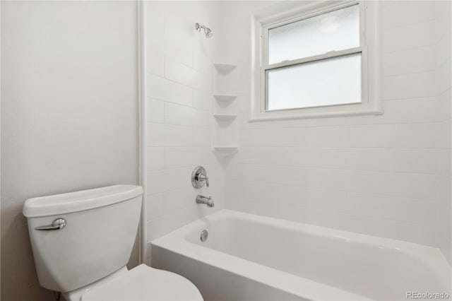 bathroom featuring tiled shower / bath combo and toilet