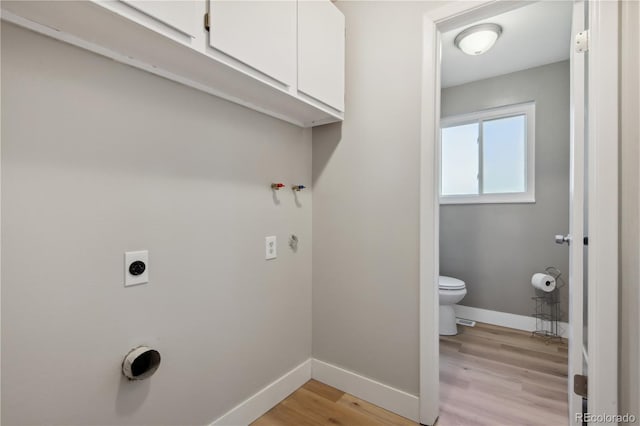 laundry room with cabinets, light hardwood / wood-style floors, and electric dryer hookup