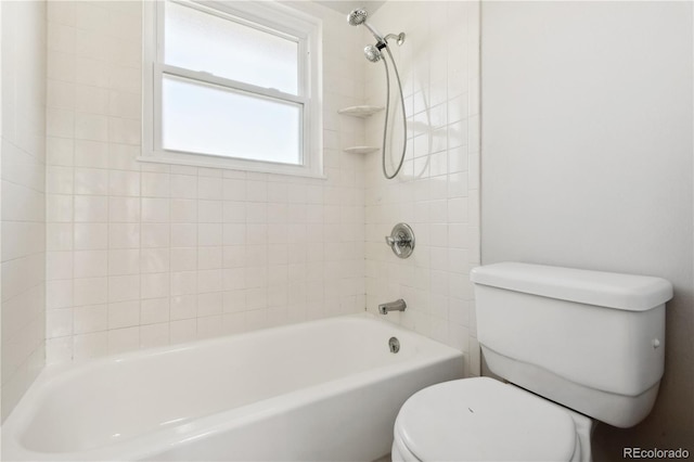 bathroom with tiled shower / bath combo and toilet