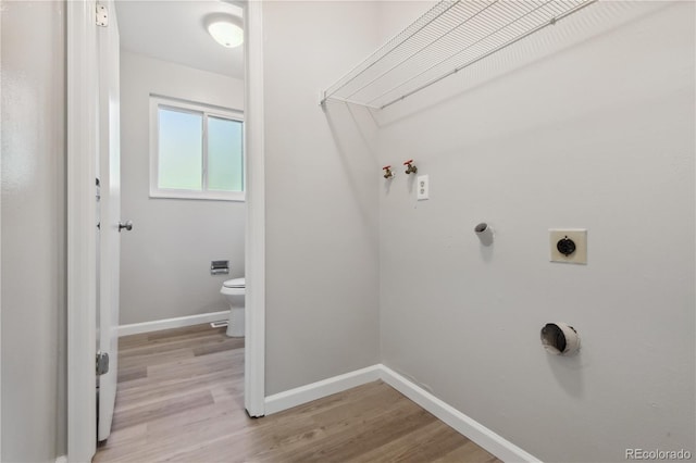 laundry area featuring hookup for an electric dryer and light hardwood / wood-style floors