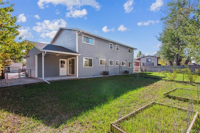 rear view of house featuring a lawn and a patio