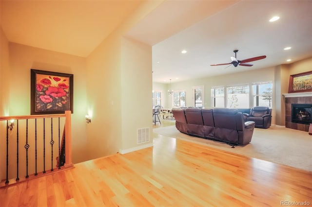 living room with hardwood / wood-style flooring, plenty of natural light, and a tile fireplace