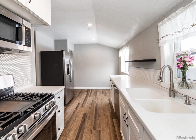 1726 E Evans Ave, Pueblo, CO 81004 - kitchen featuring stainless steel appliances, a sink, white cabinetry, light countertops, and lofted ceiling