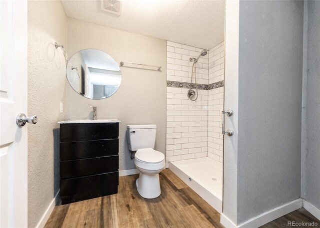 1726 E Evans Ave, Pueblo, CO 81004 - bathroom featuring toilet, vanity, a tile shower, and wood finished floors