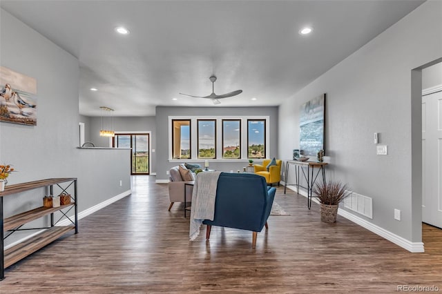 living room featuring dark wood-type flooring and ceiling fan