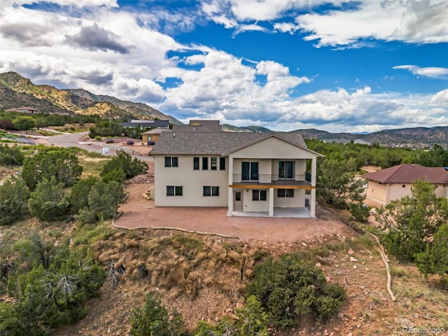 rear view of property with a mountain view and a patio