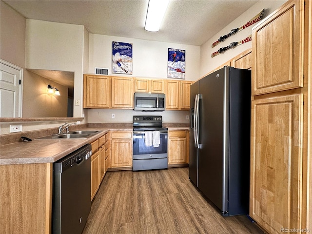 kitchen featuring stainless steel appliances, a textured ceiling, sink, dark hardwood / wood-style floors, and light brown cabinetry