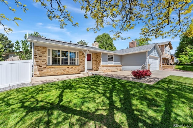 1606 S Flanders Way, Aurora, CO 80017 - ranch-style home with brick siding, a chimney, roof mounted solar panels, and concrete driveway