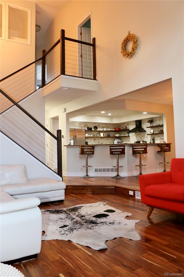 8747 Mesquite Row, Lone Tree, CO 80124 - living area featuring wood finished floors, a high ceiling, and stairs