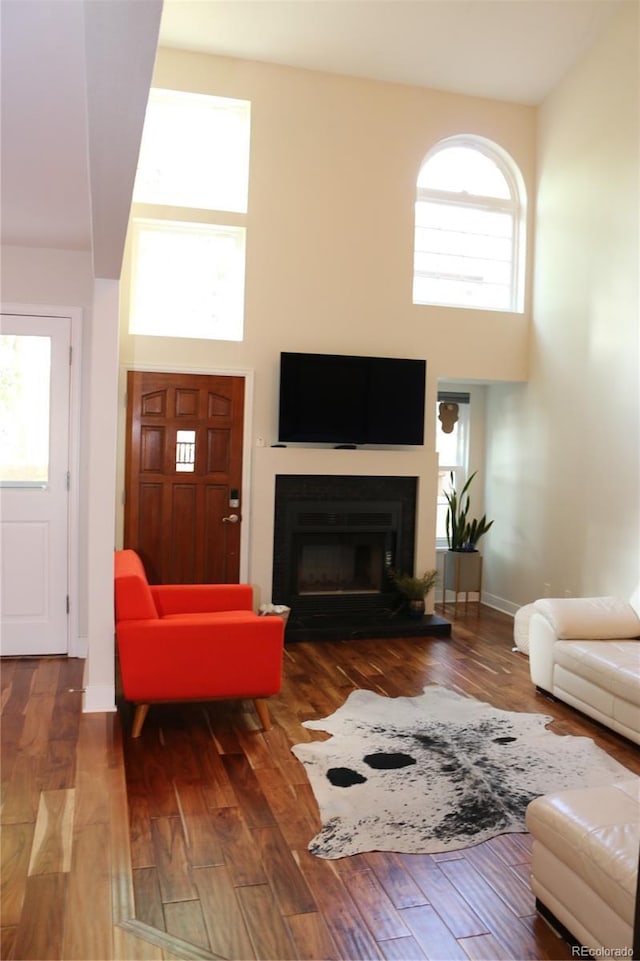 8747 Mesquite Row, Lone Tree, CO 80124 - living area featuring a towering ceiling, a fireplace, and wood finished floors