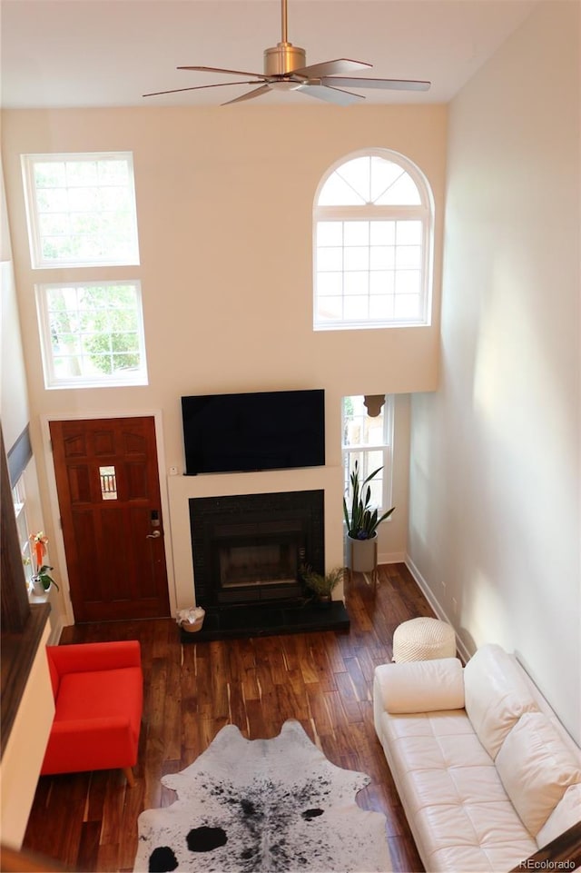 8747 Mesquite Row, Lone Tree, CO 80124 - living area with wood finished floors, ceiling fan, a fireplace, and a high ceiling