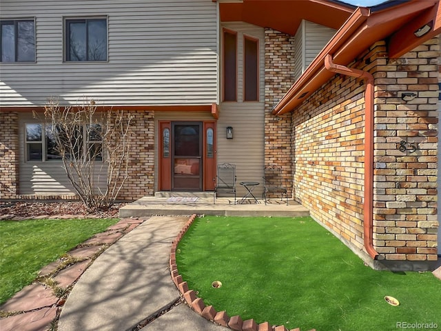 doorway to property featuring brick siding