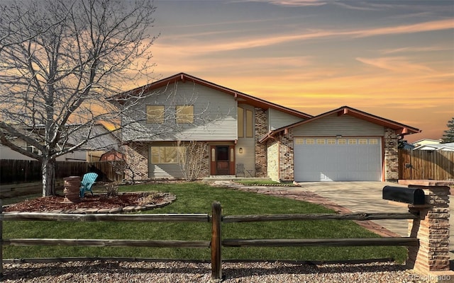 view of front of house featuring an attached garage, concrete driveway, a fenced front yard, a lawn, and brick siding