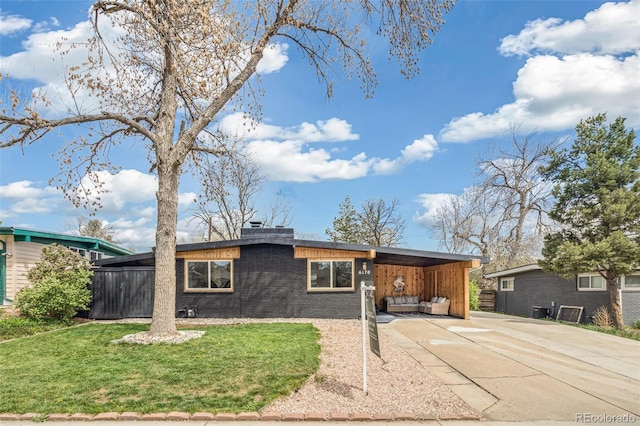 6170 Estes Ct, Arvada, CO 80004 - view of front of house with a front yard, a chimney, an attached carport, brick siding, and driveway
