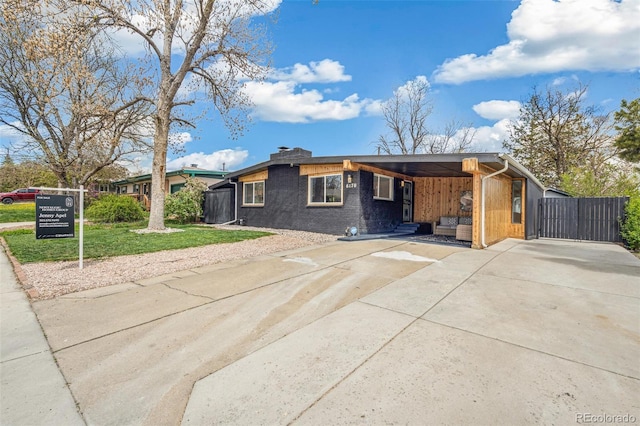 6170 Estes Ct, Arvada, CO 80004 - view of front facade featuring a gate, brick siding, fence, a front lawn, and concrete driveway