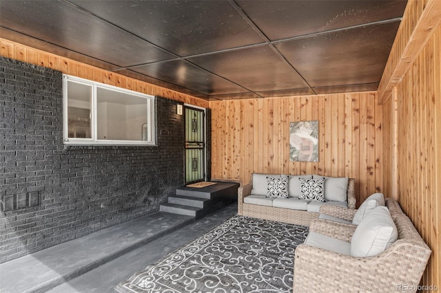 6170 Estes Ct, Arvada, CO 80004 - living area with wooden walls, concrete floors, and brick wall