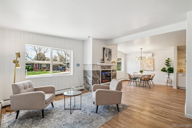 6170 Estes Ct, Arvada, CO 80004 - living room with baseboards, baseboard heating, light wood finished floors, and a fireplace